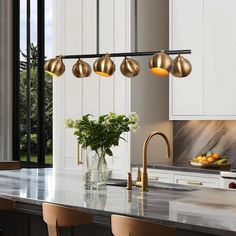 a kitchen with marble counter tops and gold pendant lights