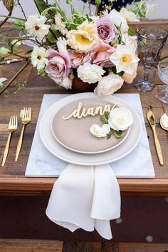 a place setting with flowers and goldware