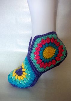 a close up of a person's feet wearing crocheted slippers and socks