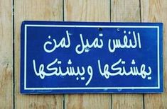 a blue sign that is on the side of a wooden fence with writing in arabic