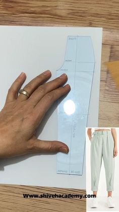 a person's hand on top of a piece of paper next to a sewing pattern