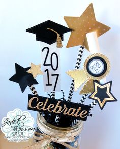 graduation decorations in a mason jar on a table with gold stars and confetti