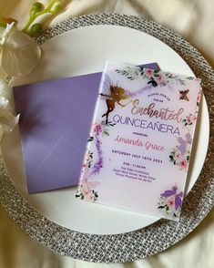 a purple and white wedding card on a plate