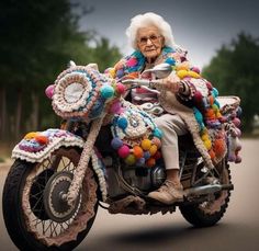 an old woman riding on the back of a motorcycle covered in crocheted decorations