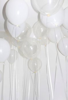 white balloons and streamers are floating in the air