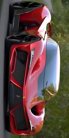 a red sports car parked on the side of a road next to a lush green field