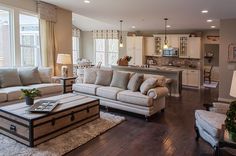 a living room filled with furniture next to a kitchen