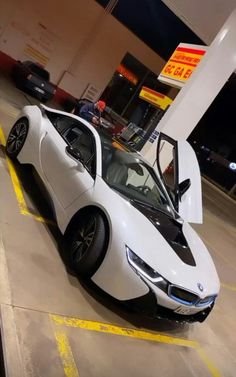 a white sports car parked in front of a gas station