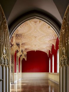 an empty room with red walls and gold trim around the archways is pictured in this image