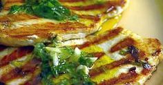 two grilled sandwiches on a white plate with sauce and green garnishes