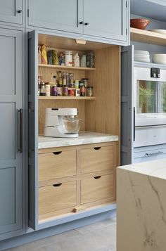 an open cabinet in a kitchen with lots of cupboard space and drawers on the side