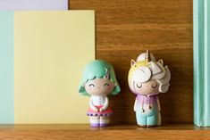 Two momiji dolls, one unicorn, stand on table