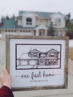 a person holding up a sign that says our first home