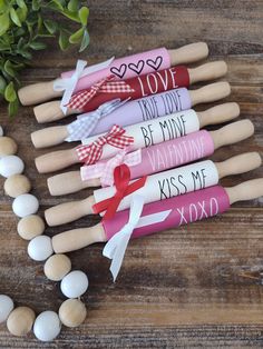 wooden pegs with valentine's day message on them sitting next to some eggs