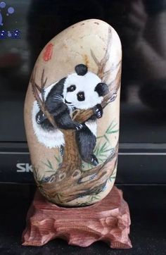 a panda bear sitting on top of a tree branch