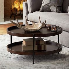 a coffee table with antlers on it in front of a couch and fire place