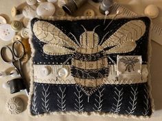 a black and white purse sitting on top of a table next to sewing needles, buttons and other items