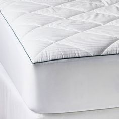 an image of a mattress topper that is white and has no sheets on it