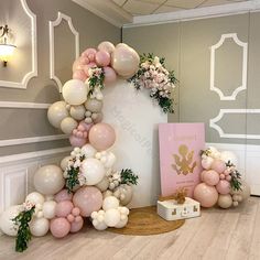 balloons and flowers are arranged in the shape of an arch for a baby's first birthday party