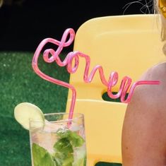 a woman sitting at a table with a mojito and drink in front of her