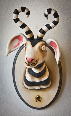 a ceramic animal head mounted to the side of a wall with candy canes on it