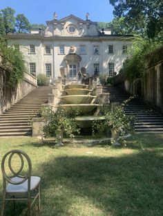 an outdoor fountain in front of a large building with steps leading up to the entrance