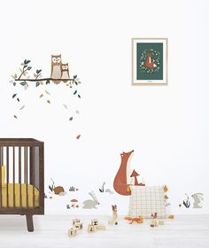 a baby's room with an owl and fox wall decal on the wall