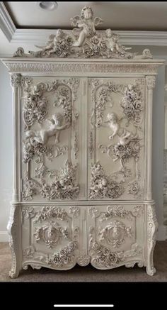 an ornate white armoire in a room