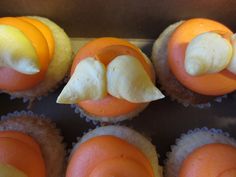 some cupcakes with orange and white frosting on them