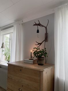 a wooden dresser sitting next to a window