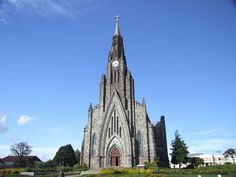 a large cathedral with a clock on it's steeple and flowers in the foreground