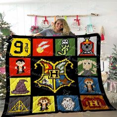 a woman is holding up a quilt made to look like video game characters and numbers