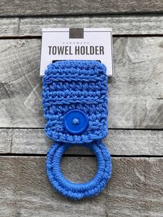 a blue crocheted towel holder with a button on the front and back of it