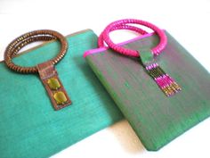 two purses are sitting next to each other on a white surface with pink and green beads