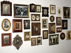 a wall with many framed pictures on it