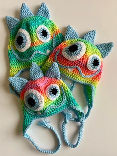 three crocheted hats with eyeballs on them