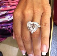 a close up of a person's hand with a heart shaped diamond on it