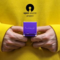 a person in a yellow shirt holding a purple object with the words open source project written on it