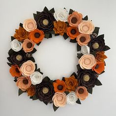 a wreath made out of paper flowers and leaves