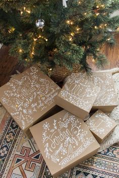 three boxes sitting on top of a rug next to a christmas tree