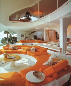 an orange and white living room with lots of couches in the middle of it