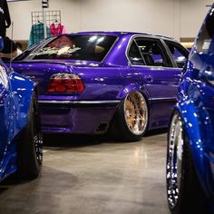 two blue cars parked next to each other in a garage