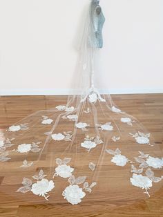 a white veil with flowers on the floor