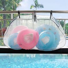 three inflatable swimming floats sitting on the edge of a pool