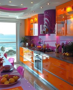 an orange and pink kitchen with the ocean in the backgrounnd, is shown