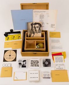 an assortment of items are displayed on a white surface with yellow and black papers, cards, and ink