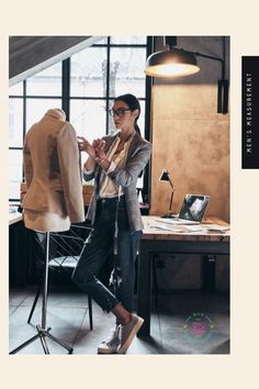 a woman standing in front of a desk with a jacket on it