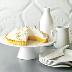 a white plate topped with a piece of pie next to a cup and saucer