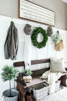 a wooden bench sitting in front of a wall filled with wreaths and potted plants