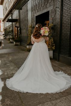 a woman in a wedding dress walking down the street